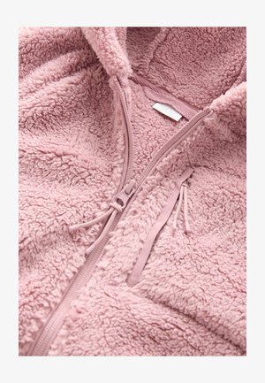 Duks s kapuljačom na patentni zatvarač od flisa svijetloružičaste boje, koji ima meku teksturu, patentni zatvarač punom dužinom, ukrase s vezicama i malu unutarnju etiketu.