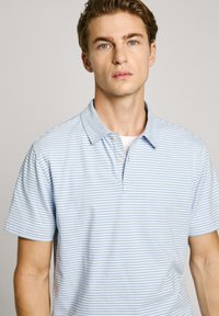 Svetle modrá polo košile s horizontálními bílými pruhy. Bavlněný materiál, s límečkem, krátké rukávy, se třemi knoflíky na zapínání.