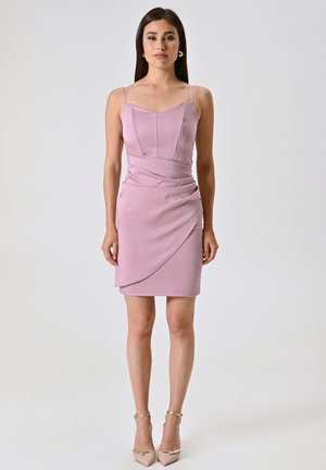 Robe ajustée rose clair avec fines bretelles, corsage structuré, détail drapé sur le devant et ourlet asymétrique. Texture lisse.