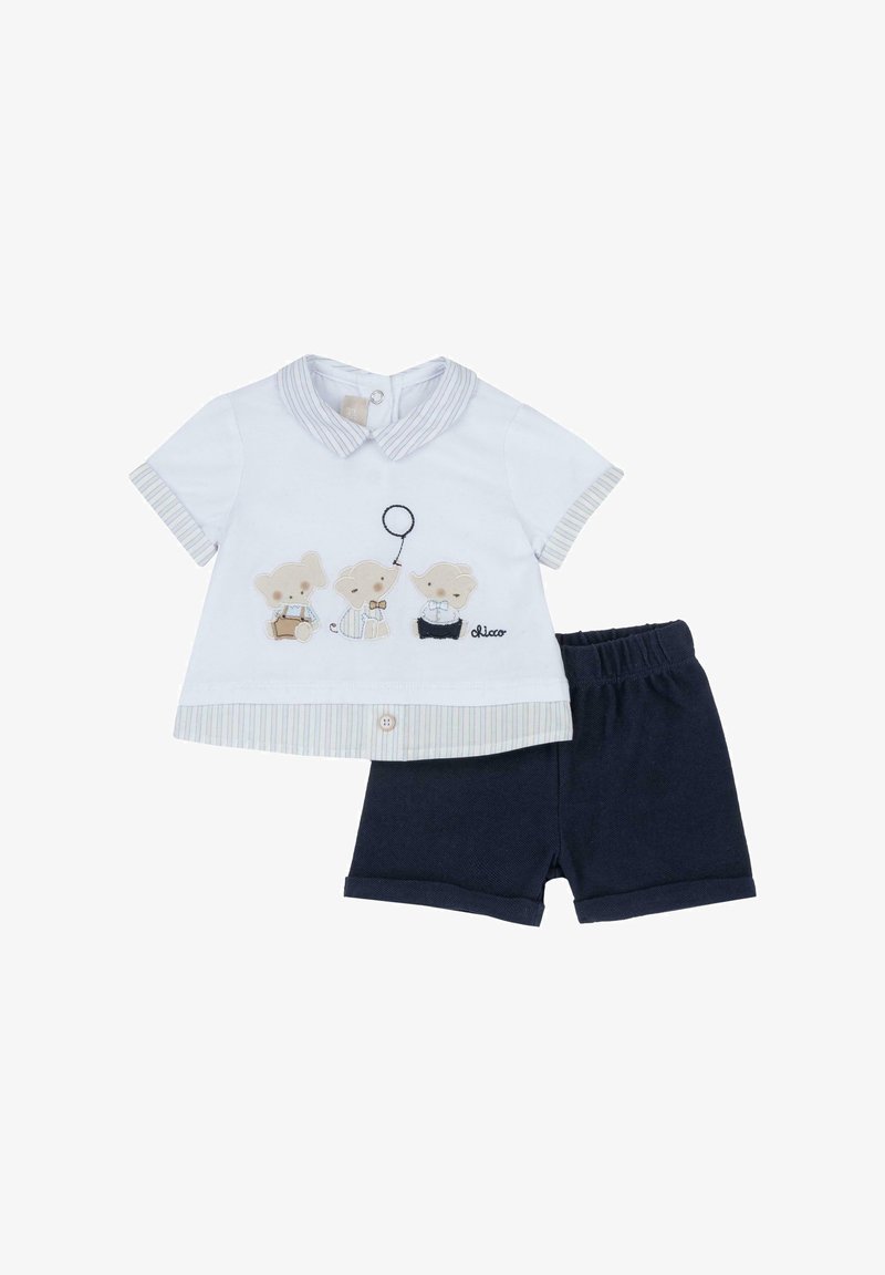 Conjunto de ropa infantil que incluye una camisa blanca de manga corta con cuello a rayas y bordado de oso, acompañada de pantalones cortos azul marino.