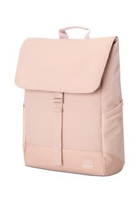 Sac à dos rose clair avec rabat, sangle avant à boucle, poches latérales et poignée supérieure, debout sur fond blanc.