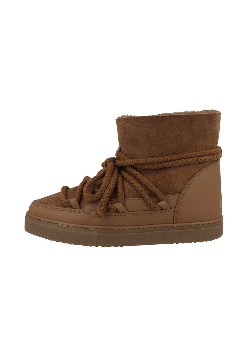 Botas de ante marrón hasta el tobillo con gruesos cordones de cuerda, un puño acolchado y una suela de goma texturizada. Diseñadas para la comodidad y el calor.