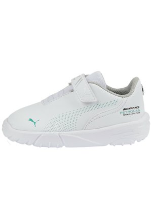 Biały sneaker Puma z turkusowym logo, paskiem na rzep i brandingiem zespołu AMG Petronas Formuła 1 z boku.