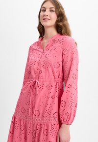 Rosa Baumwollkleid mit Broderie Anglaise Detail, knöpfbare Vorderseite, Kragen und elastischen Ärmeln. Mit Kordelzug in der Taille, gestuftem Rock.