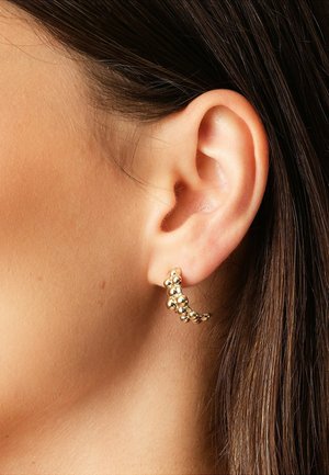 Goldohrringe mit einem gewellten Design, die mehrere sphärische Akzente aufweisen. Die Ohrringe sind glänzend und dekorativ, geeignet für einen engen Sitz.