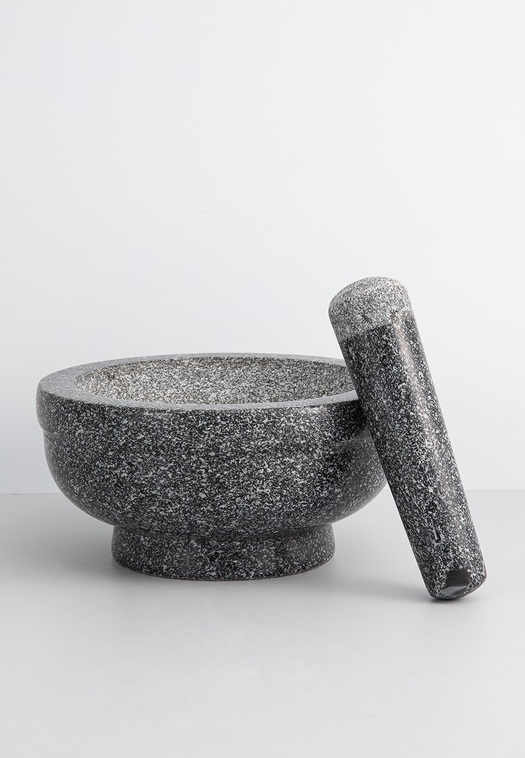 Schwarzes, gesprenkeltes Granit-Mörser- und Stößel-Set. Die Schüssel hat einen abgerundeten Boden, dicke Wände; der Stößel ist zylindrisch mit einer strukturierten Oberfläche.
