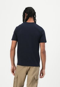 Marineblauwe T-shirt met korte mouwen van katoen met een ronde halslijn, met een strak ontwerp en een fijne textuur, gezien vanaf de achterkant.