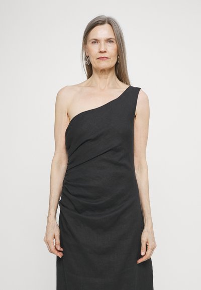 One-shoulder black linen dress with ruched detailing along the side. The fabric appears textured and drapes elegantly.