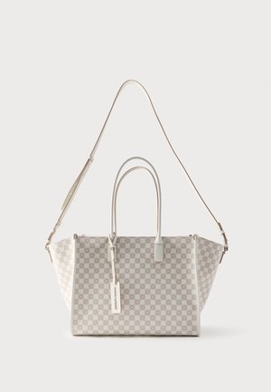 Λευκή τσάντα ώμου με γεωμετρικό μοτίβο, διπλές λαβές στο επάνω μέρος, ρυθμιζόμενο λουρί ώμου και ορθογώνια ετικέτα που κρέμεται από τη λαβή.