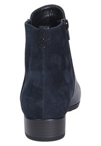 Botte à cheville en suède bleu marine avec des accents en cuir noir, fermeture zippée sur le côté et un talon texturé, présentant une finition lisse et un bout rond.