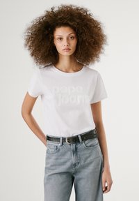 Hvit bomull T-skjorte med hevet "pepe jeans" tekst, kombinert med lyseblå denimjeans og et svart belte med sølvspenne.