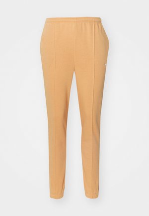 Orange jogger pants made of soft cotton, featuring an elastic waistband, tapered legs, and a subtle white logo on the left thigh.