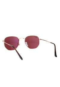 Occhiali da sole con montatura dorata e lenti ottagonali di colore rosa scuro. Le astine presentano un motivo tartaruga. I naselli regolabili aumentano il comfort.