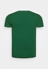 Jednolity, ciemnozielony, krótko rękawowy t-shirt pokazany z tyłu z widocznymi detalami szwami przy dekolcie i rękawach.