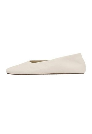 Beige flad sko med spids tå og lav sålprofil, lavet af blødt stof eller læder, set fra siden på en hvid baggrund.