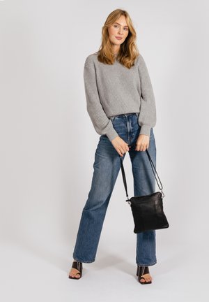 Gray ribbed sweater with balloon sleeves, high-waisted blue jeans, and a black leather crossbody bag. Open-toed brown block-heeled shoes.