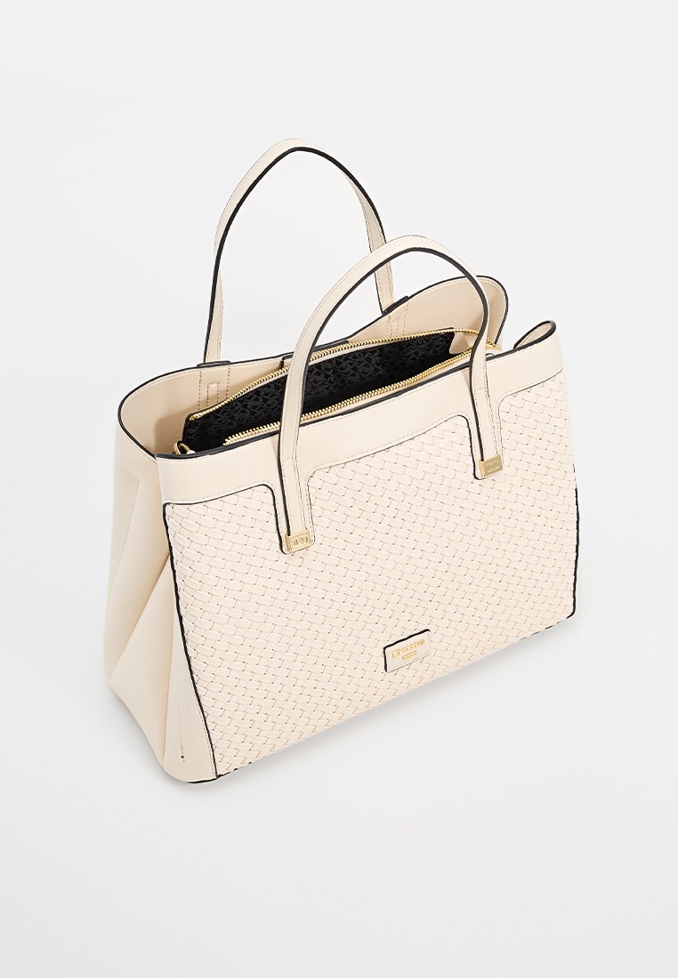 Beige geweven tote bag met dubbele handvatten, zwarte binnenzak met rits en gouden logo plaat aan de voorkant.