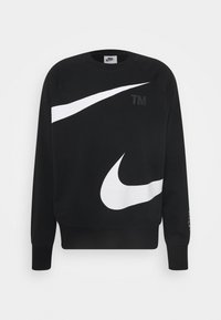 Svart Nike-tröja med stora vita swoosh-logotyper över bröstet och ärmen, med "TM"-text på framsidan.