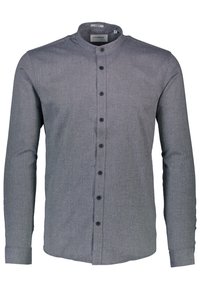 Harmaa nappikauluspaita, jossa on pitkähihaiset hihat ja mustat napit. Ominaisuuksiin kuuluu tekstuuripinta hienovaraisilla yksityiskohdilla saumoissa.