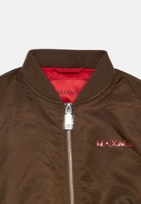 Veste bombardier marron en tissu lisse, avec un col côtelé, une fermeture éclair argentée, et une doublure intérieure rouge avec le logo "MAX&Co." en rouge.