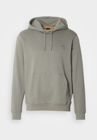 Sudadera gris con capucha en material suave, con un bolsillo frontal tipo canguro y un pequeño parche con logo en el pecho. Capucha ajustable con cordón.