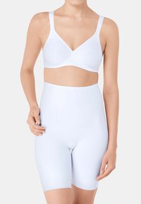 Bralette blanche à côtes avec bretelles réglables et décolleté en V, associée à un short taille haute blanc sculptant. Tissu doux et extensible.