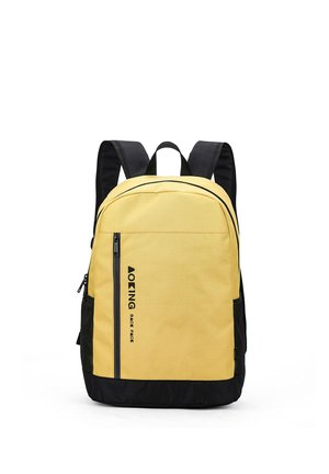 Zaino giallo e nero con tasca frontale verticale con cerniera, spallacci imbottiti neri e tasche laterali in rete, in posizione verticale su sfondo bianco.