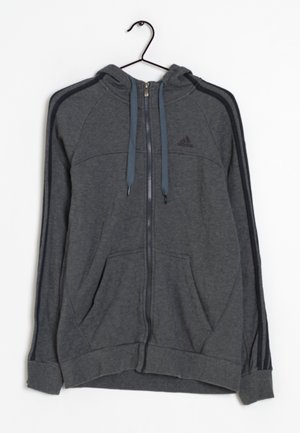 Grijze zip-up hoodie met een capuchon, voorzien van twee voorzakken, blauwe trekkoorden en zwarte zijstrepen. Gemaakt van zachte stof. Adidas-logo weergegeven.