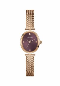 Montre en or rose avec un bracelet texturé et un cadran rond violet foncé, comportant des accents dorés et des index carrés. Nom de la marque affiché.