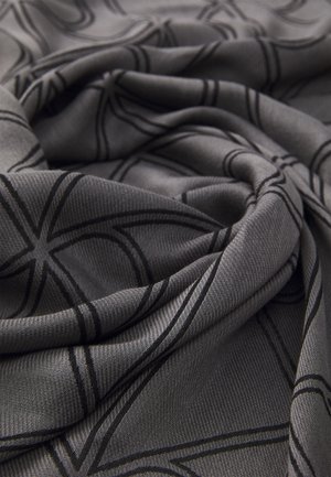 Grey patterned fabric with smooth texture. Features black geometric lines in a repeating design, showcasing draped and folded layers.