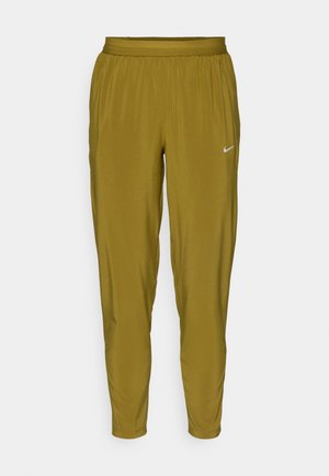 Nike track pants in olive green, featuring a tapered design, elastic waistband, and small white logo detail on the side. Smooth texture.
