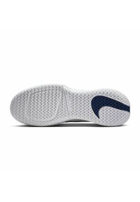 Weiße Sneaker-Sohle mit einem strukturierten Muster und einem dunkelblauen Nike Swoosh-Design auf einer Seite. Abgerundete Kanten und Rillen für Traktion.