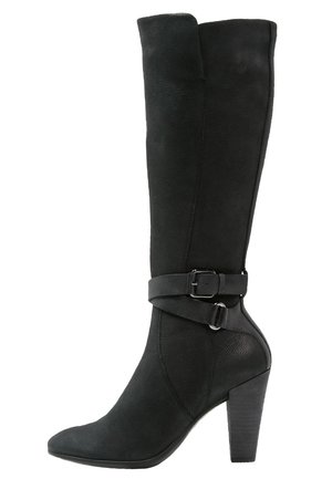 Botte en cuir noire mi-mollet avec un bout pointu, un talon haut empilé et une sangle décorative à boucle autour de la cheville.