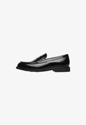Zwarte leren loafers met een gladde afwerking, ronde neus, decoratieve band en lage blokhak. Beschikt over subtiele stiksels en een instapontwerp.