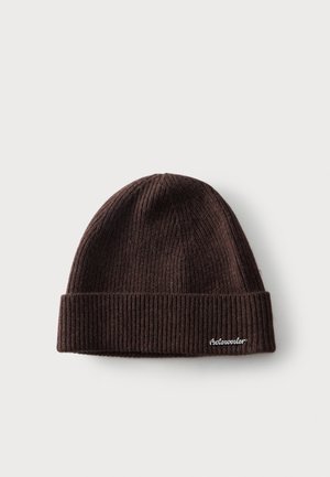 Bonnet en maille côtelée marron foncé avec revers plié et petit texte blanc brodé sur le revers.