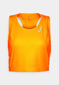 Débardeur Nike orange avec une texture en maille, un col rond dégagé et un dos nageur. Présente un logo Nike blanc sur le côté supérieur gauche.