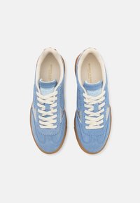 Blaue Wildledersneaker mit weißen Schnürsenkeln, die eine glatte Oberfläche und gewellte Details aufweisen. Gummisohle in Braunton. Innen-/Außendesign.