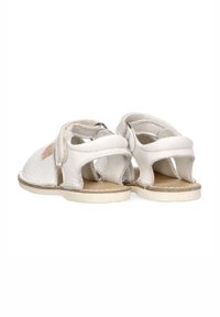 Sandalias de cuero blanco con un diseño de espalda abierta, parte superior texturizada y una suela lisa. Incluye correas ajustables para un ajuste seguro.