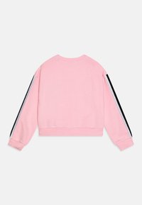Sweatshirt rose cropped à manches longues, avec des rayures noires et blanches sur les côtés des manches et des poignets et un ourlet côtelés.
