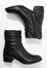 Bottes de cheville en cuir noir avec un design décontracté, fermeture éclair sur le côté, bout arrondi et talon bloc texturé. Fini lisse avec un minimum de détails de couture.