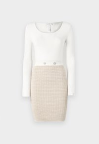 Robe en tricot avec de longues manches blanches, un corsage blanc ajusté et une jupe beige texturée. Présente deux boutons décoratifs à la taille.