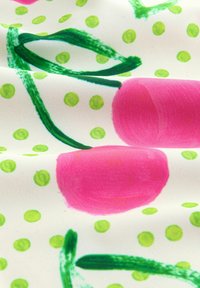 Tessuto di cotone con uno sfondo crema caratterizzato da grandi cerchi rosa e motivi a pois verdi, arricchito da spirali verdi e foglie.