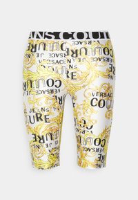 Bermudské šortky vyrobené z lesklé bílé látky s černými a žlutými ornamentálními potisky a textem "Versace Jeans Couture". Elastický pas.