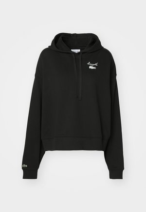 Schwarzer, kurz geschnittener Hoodie aus weichem Material, mit einer Kapuze mit Kordelzug und einem weißen gestickten Logo auf der Brust sowie grünen Akzenten an den Ärmeln.