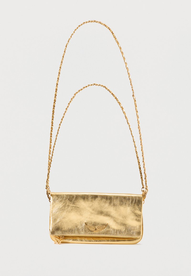 Μικρή μεταλλική χρυσή δερμάτινη τσάντα ώμου με κλείσιμο με καπάκι και μακριά χρυσή αλυσίδα λουράκι σε λευκό φόντο.