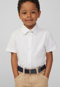 Witte korte mouwen knoopshirt met een klassieke kraag, gecombineerd met beige broek en een marineblauwe riem. Gladde stof, comfortabele pasvorm.