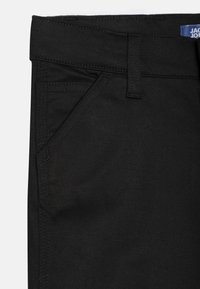 Svart denimjeans med klassisk femlommersdesign, solid søm og en jevn tekstur samt et synlig merkeetikett i livet.