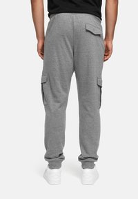 Les joggers cargo gris présentent une taille côtelée, deux poches latérales et des chevilles élastiquées. Fabriqués en coton doux, leur design est pratique et décontracté.