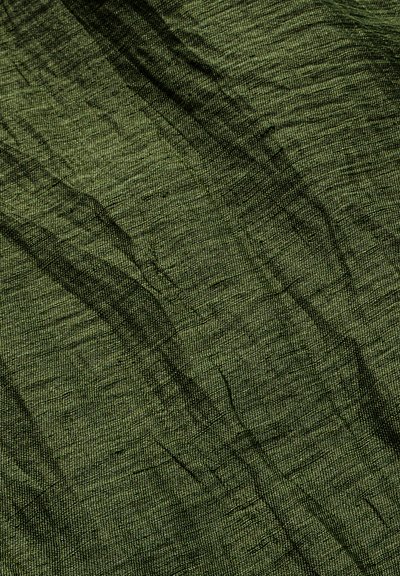 Tissu vert texturé avec des plis horizontaux et verticaux irréguliers et un motif de surface légèrement rugueux.