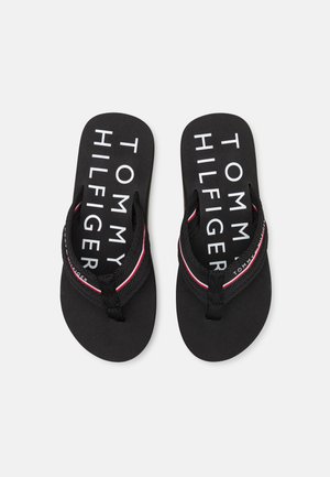 Black flip-flops with a textured footbed, featuring a logo in white, red, and blue accents on the strap. Simple, flat design.